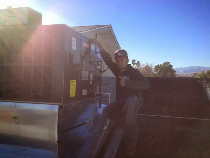 HVAC technician performing AC Tune-Up on a rooftop unit in Galt